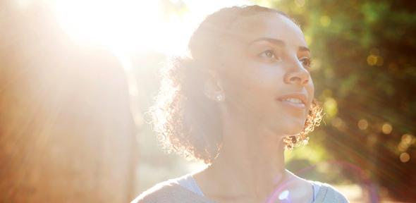 Smiling girl with the sun behind her