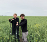 Students pose for a photo in a green field 