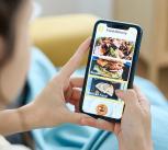 Woman using a food delivery app on her mobile phone