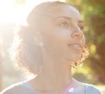 Smiling girl with the sun behind her