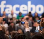 Members of the audience take pictures as President Barack Obama participates in a town hall meeting moderated by CEO Mark Zuckerberg at Facebook headquarters in Palo Alto, Calif. April 20, 2011