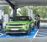 People charging their electric cars at charging station