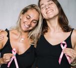 Two women holding pink ribbons