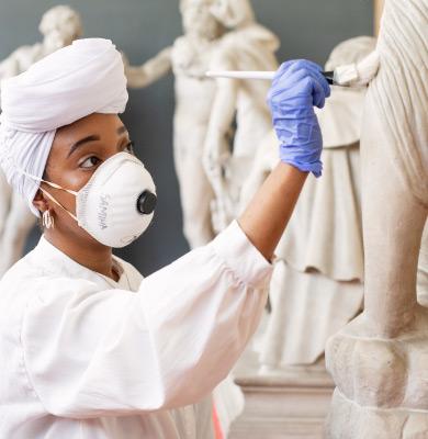 Woman cleaning museum exhibit.