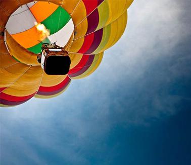 A hot air baloon soars in a blue sky. Photograph: Agustín Faggiano - Fotografía on Getty