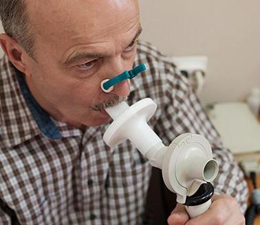 Man testing breathing function by spirometry.