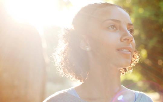 Smiling girl with the sun behind her