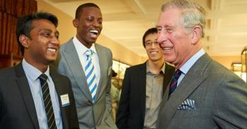 King Charles smiling with a group of Cambridge students