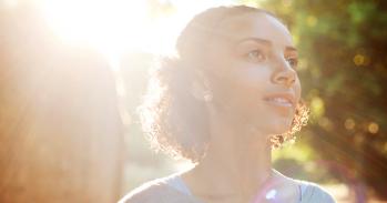 Smiling girl with the sun behind her