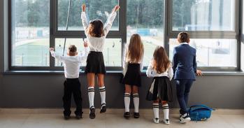 School children watching a sports game from indoors