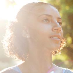 Smiling girl with the sun behind her