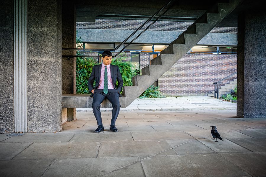 Nikhil Krishnan at Sidgwick Site, sitting on steps, looking at crow