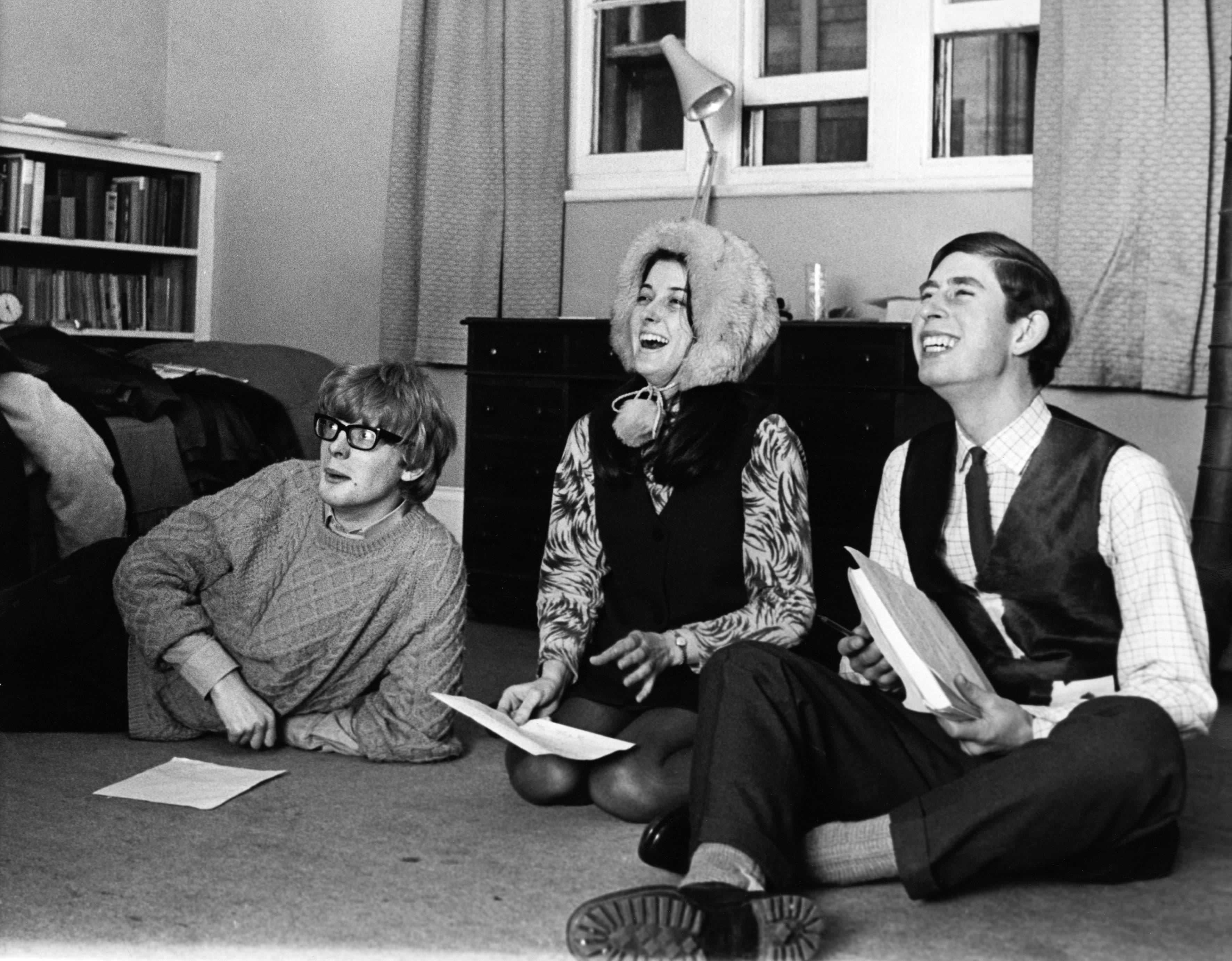 Prince Charles reads a play with his friends sitting on the floor of a College room