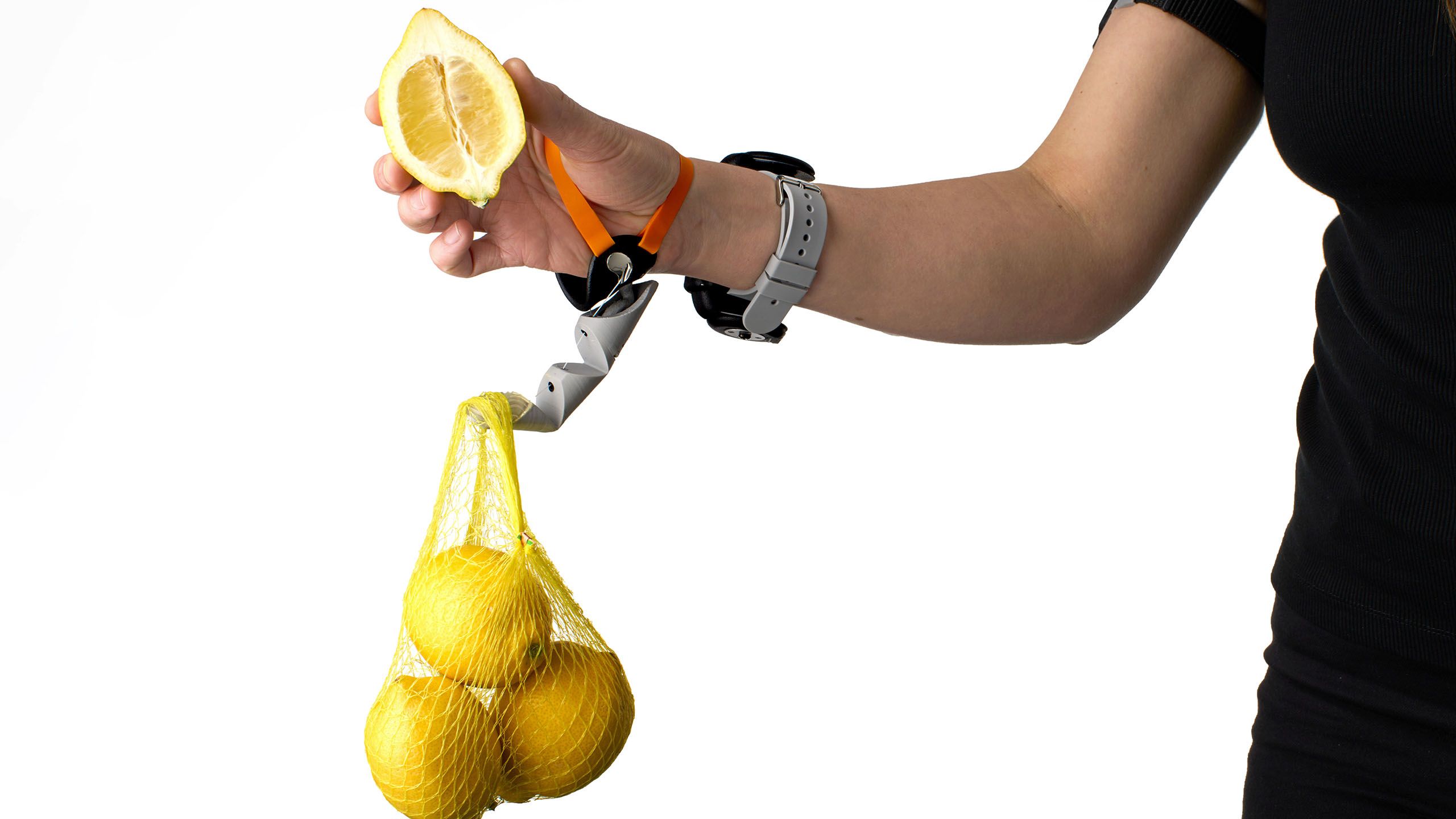 Third Thumb helping hold a bag of lemons