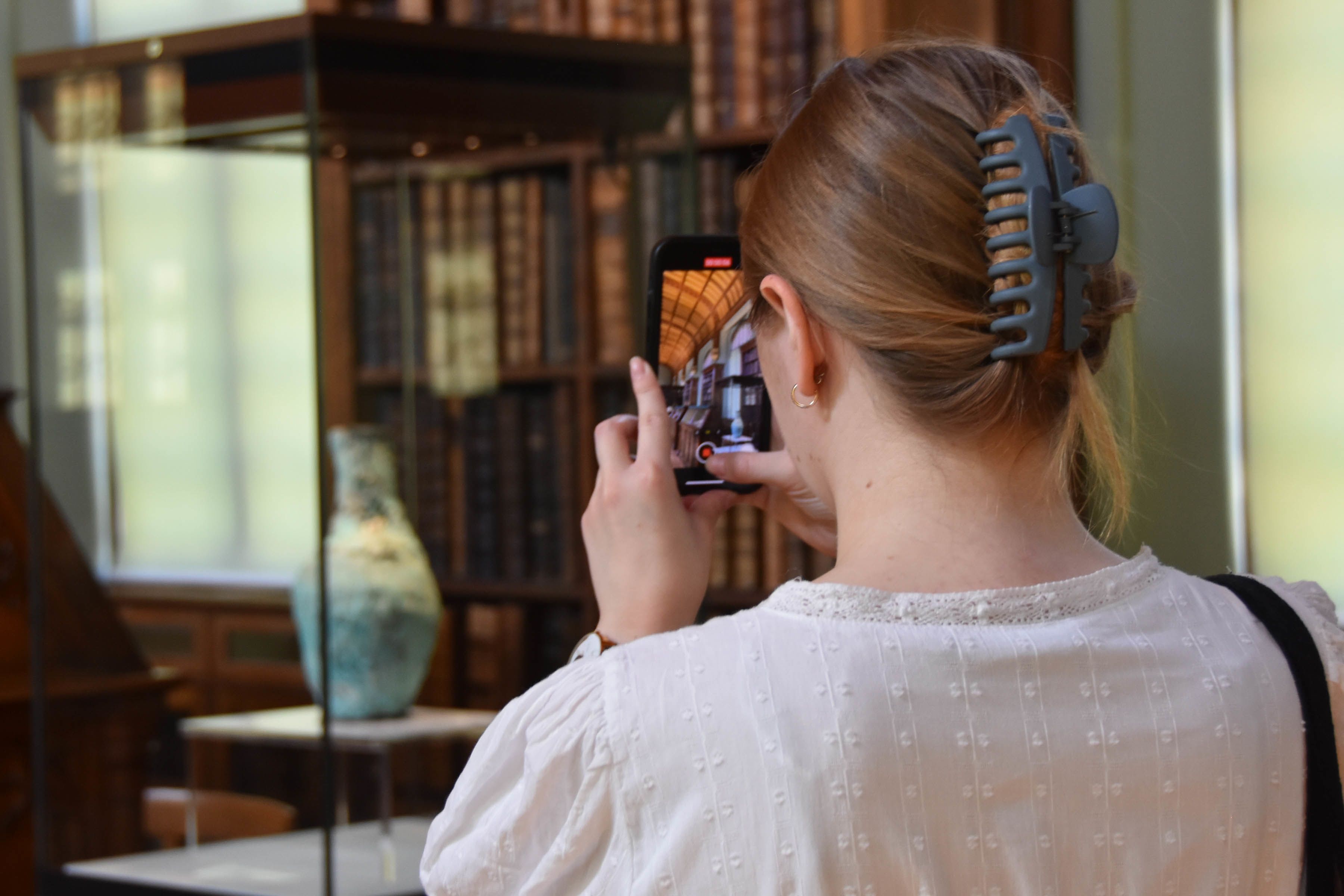 A person takes a picture of the Parker Library at Corpus Christi College.