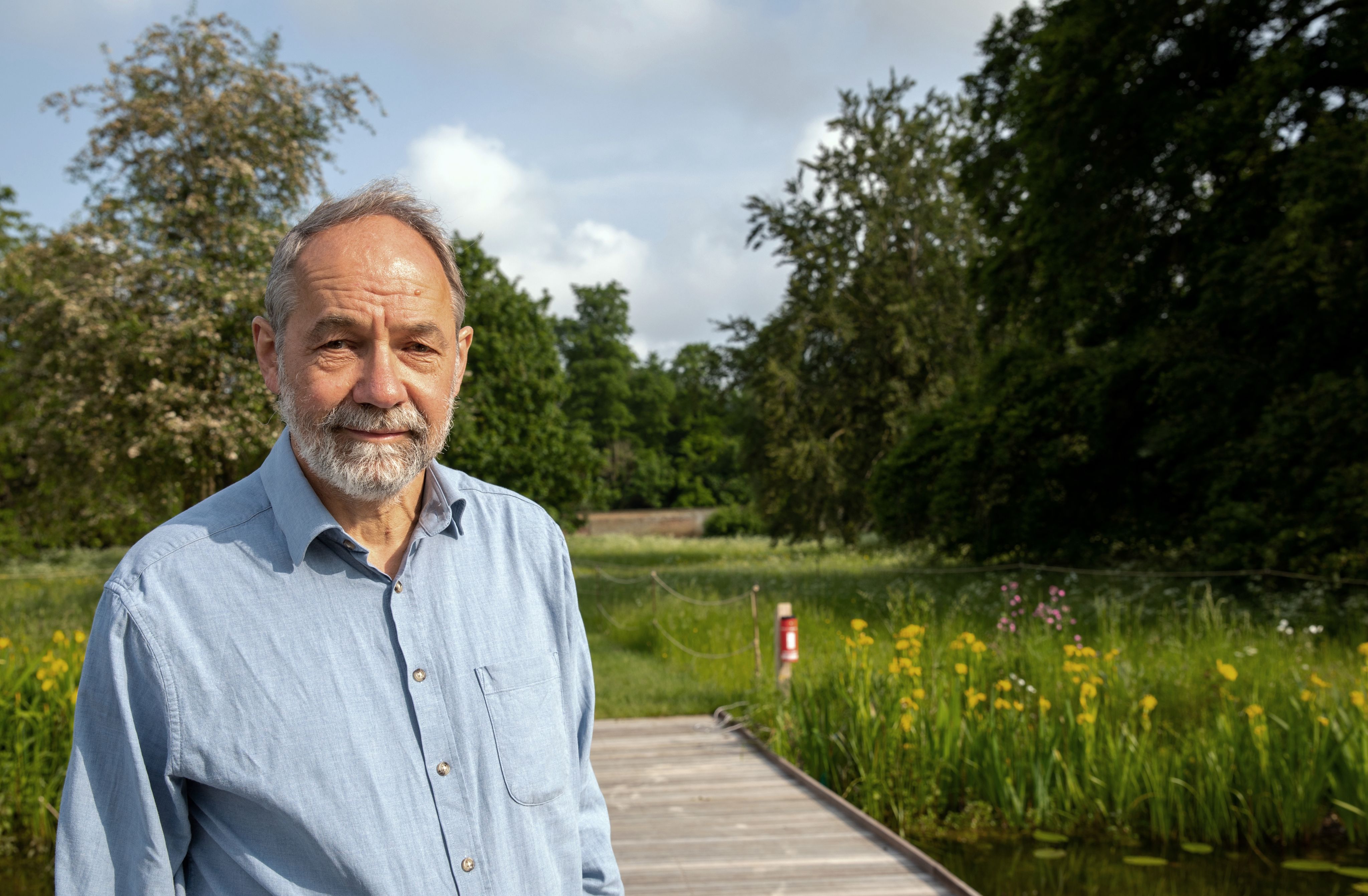 William Sutherland outdoors with grassy meadow behind.