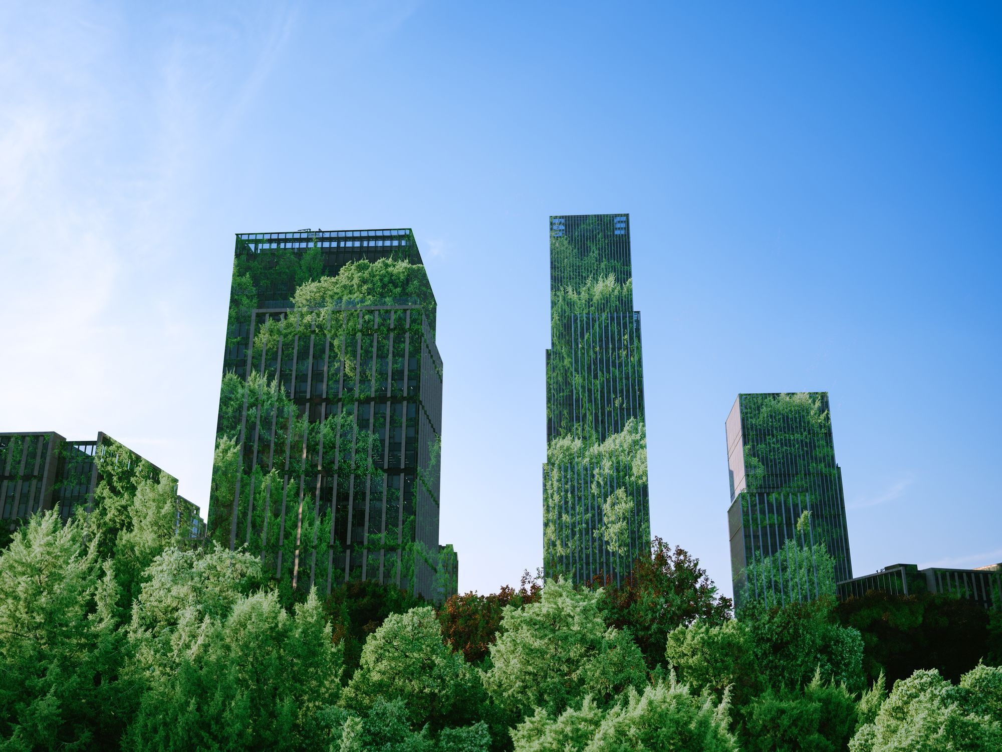 Tall glass buildings with trees reflected across them