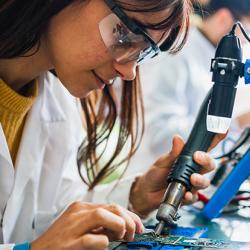 Two people working on circuit boards in an office